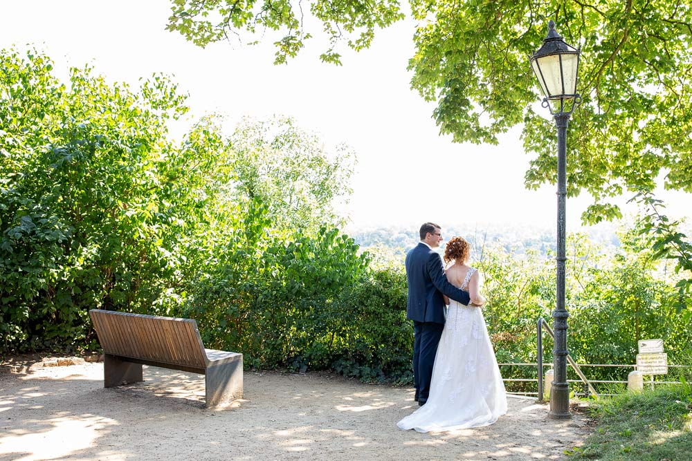 Ein Brautpaar steht im Lauenburger Schlosspark und blickt romantisch in die Ferne